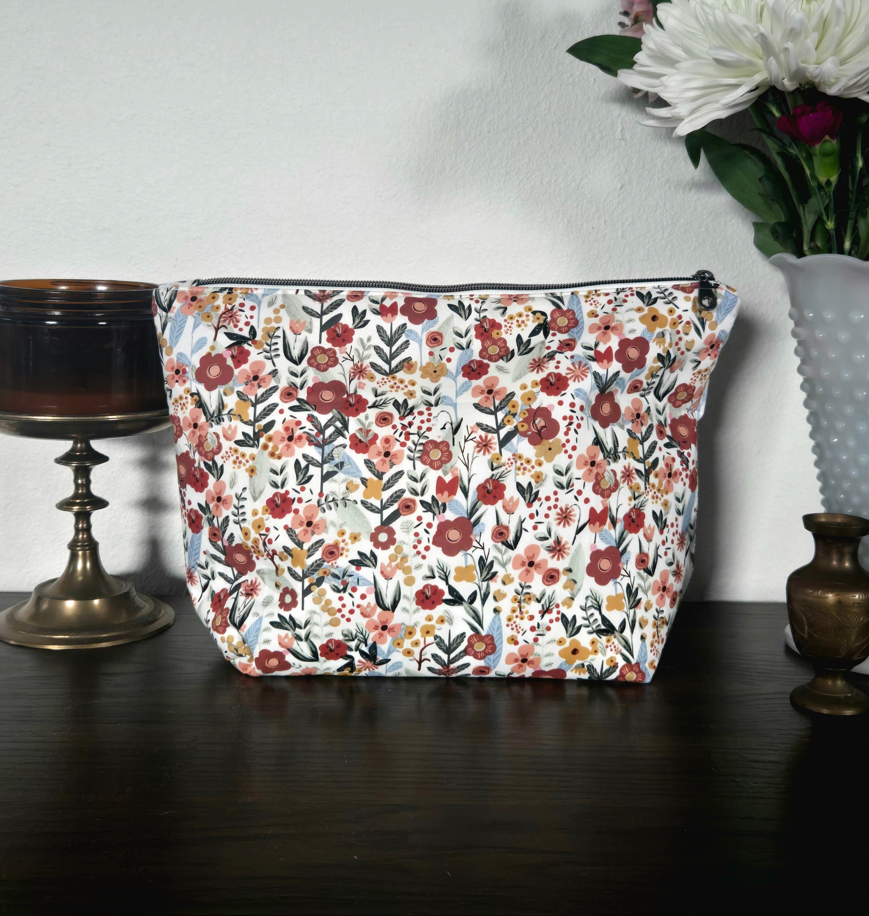 Floral-patterned pouch on a dark surface with a light background