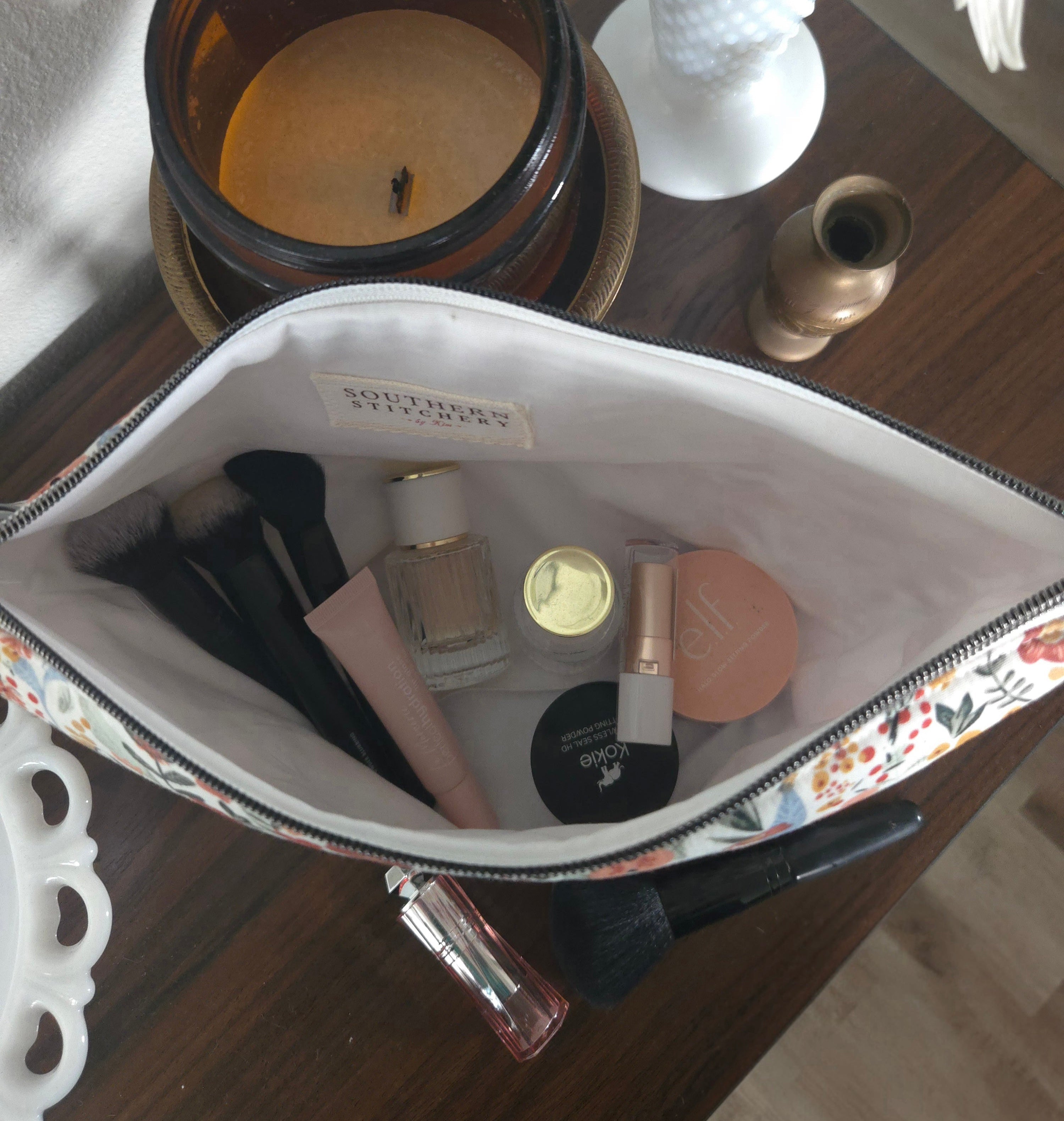 Makeup bag with cosmetic items on a wooden surface